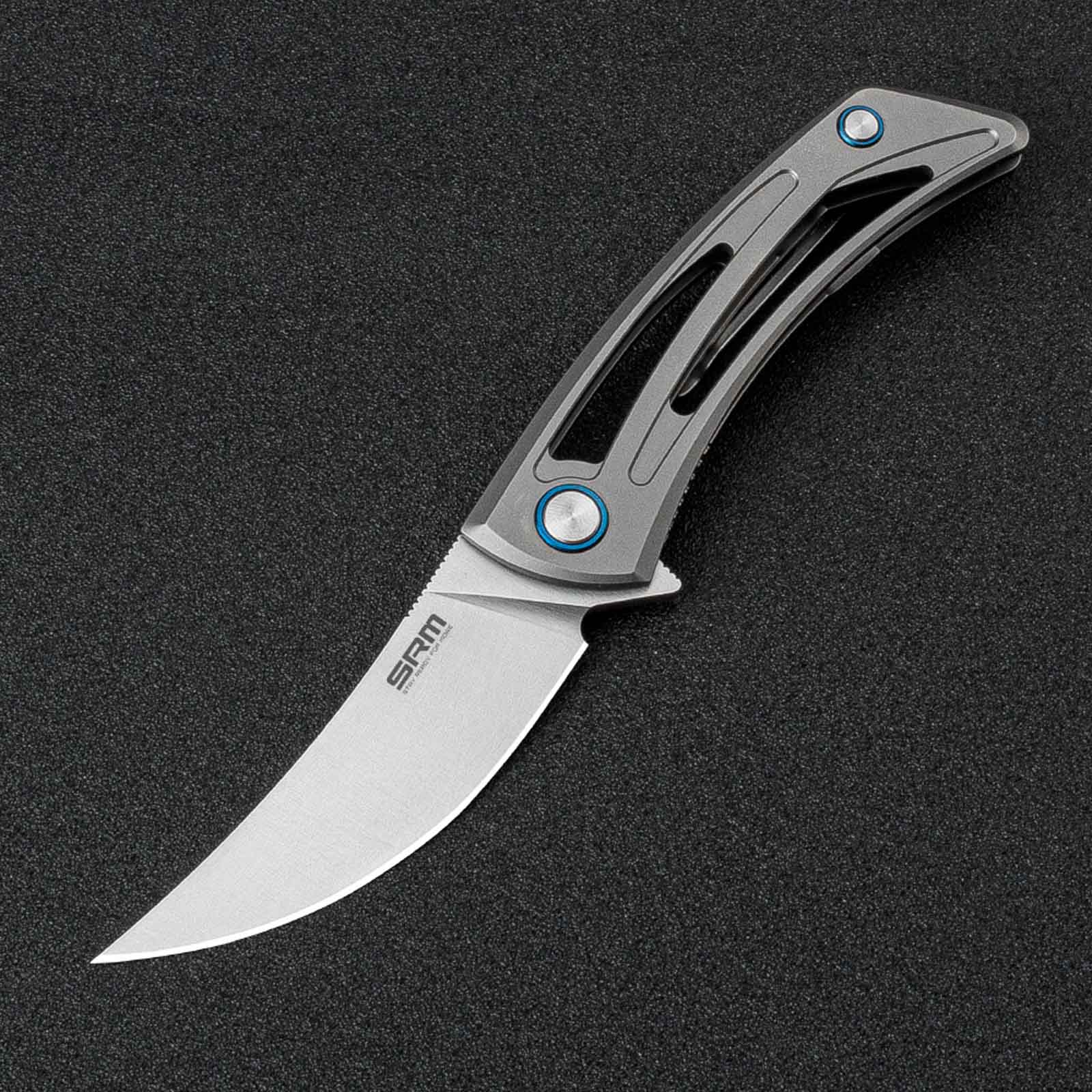 The image shows the SRM Unicorn 7415-TZ frame lock knife placed on a black light-absorbing cloth.