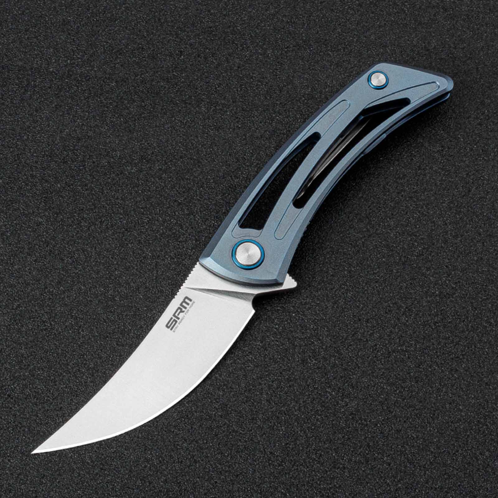 The image shows the SRM Unicorn 7415-TE frame lock knife placed on a black light-absorbing cloth.
